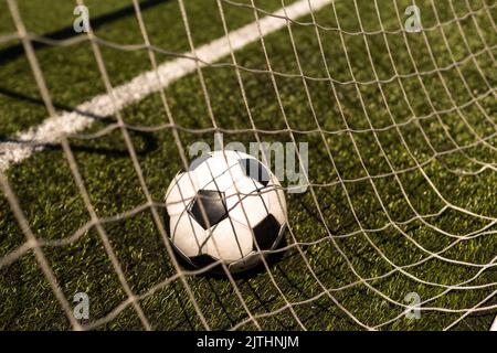 ballon de football blanc et noir sur fond d'herbe verte et de stade. idée de paris sportifs. Banque D'Images