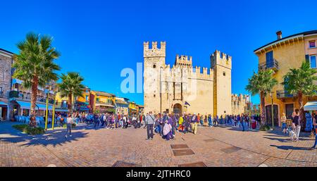 SIRMIONE, ITALIE - 10 AVRIL 2022 : Panorama de la place Piazza Castello avec restaurants en plein air et château médiéval Scaligero avec de grandes tours et m Banque D'Images