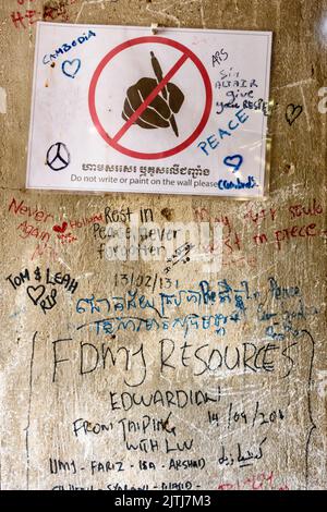 Les messages écrits sur les murs par les visiteurs du Musée du Génocide de Tuol Sleng, avec un signe pour leur demander de ne pas écrire ou peindre sur les murs, Phnom Penh, où les Khmers rouges, sous la direction de Pol Pot, torturé des milliers de personnes avant de les tuer. Banque D'Images