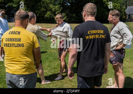 Les entraîneurs enseignent les règles et techniques de la Wrestling cornish avant le début du Grand Tournoi de la Wrestling cornish sur le village pittoresque g Banque D'Images