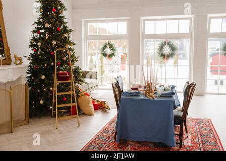 Décoration de Noël dans le salon avec grandes fenêtres, table à manger et sapin de Noël Banque D'Images