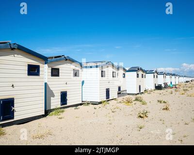 Un groupe de maisons de vacances est vu placé au bord de la plage. La plage de Hoek van Holland est de 250 mètres de large et de 3,5 km de long, située dans l'angle sud-ouest de la Hollande, d'où le nom. Les dunes avec des pistes cyclables et de randonnée librement accessibles se trouvent derrière elles. Pendant la Seconde Guerre mondiale, le crochet était l'un des endroits les plus importants pour la Wehrmacht à cause de son port, qui comprenait une partie importante et stratégique du mur de l'Atlantique. En raison du beau temps de ce week-end, les Hollandais et les touristes étrangers pouvaient profiter de la plage en marchant, en nageant et en pêchant. Banque D'Images