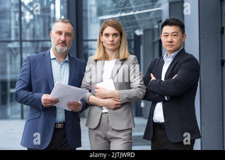 Une équipe de chefs d'équipe et de spécialistes expérimentés, un groupe diversifié de gens d'affaires, trois personnes dans les vêtements d'affaires sont sérieux et se concentrent dans les vêtements d'affaires regardant la caméra Banque D'Images