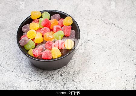 Gommies colorées dans un bol noir sur un comptoir de cuisine en pierre Banque D'Images