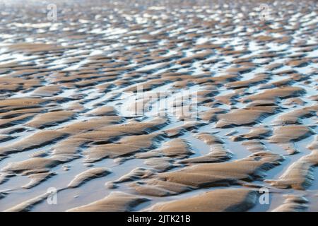 Vue typique de la côte après la marée haute, avec l'eau salée laissant des motifs étonnants sur la plage tandis que l'eau se trouve un chemin de retour Banque D'Images