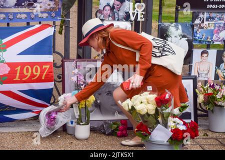 Londres, Royaume-Uni. 31st août 2022. Une femme dépose des fleurs devant le palais de Kensington. Les gens ont apporté des fleurs, des photos et d'autres hommages pour marquer l'anniversaire de la mort de la princesse Diana en 25th. (Image de crédit : © Vuk Valcic/SOPA Images via ZUMA Press Wire) Banque D'Images