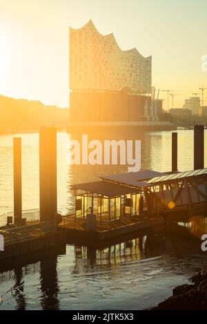 Lever du soleil à l'Elbphilharmonie, Hafencity et un quai de ferry dans la rivière Elbe dans le port de Hambourg, en Allemagne Banque D'Images