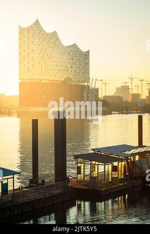 Lever du soleil à l'Elbphilharmonie, Hafencity et un quai de ferry dans la rivière Elbe dans le port de Hambourg, en Allemagne Banque D'Images