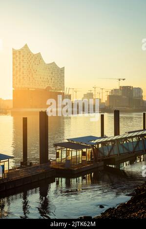 Lever du soleil à l'Elbphilharmonie, Hafencity et un quai de ferry dans la rivière Elbe dans le port de Hambourg, en Allemagne Banque D'Images