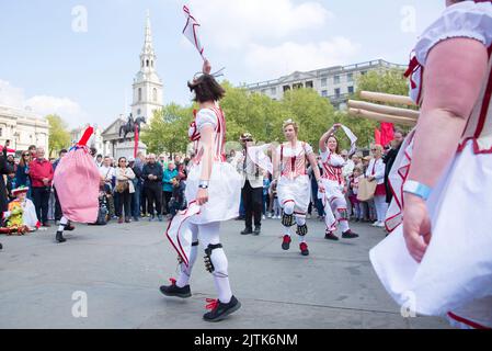 Les gens regardent les danseuses de Morris pendant qu'ils se rassemblent pour les célébrations de la fête de St George à Trafalgar Square, dans le centre de Londres. Banque D'Images