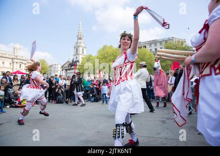 Les gens regardent les danseuses de Morris pendant qu'ils se rassemblent pour les célébrations de la fête de St George à Trafalgar Square, dans le centre de Londres. Banque D'Images