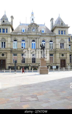 Statue de WE Forster, député libéral de Bradford à partir de 1865 sur Forster Square, avec le centre artistique Kala Sangam au-delà, à Bradford, West Yorkshire, Royaume-Uni Banque D'Images