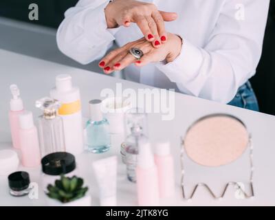 femme senior mains cosmétiques examen produit de beauté Banque D'Images