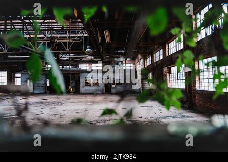 Un réservoir vide abandonné avec un plafond, des escaliers et des bureaux en bois avec des fenêtres Banque D'Images