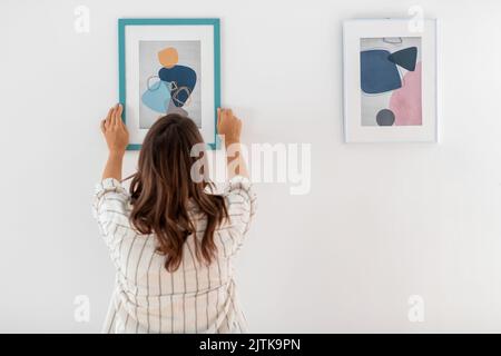 femme décorant la maison avec l'image dans le cadre Banque D'Images