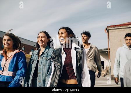 Jeunes femmes multiraciales gaies avec des amis qui apprécient la ville Banque D'Images