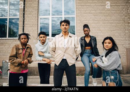 Portrait de jeunes amis multiraciaux confiants devant le mur Banque D'Images