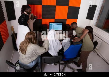 Chanteur avec compositeurs et musiciens en studio d'enregistrement Banque D'Images