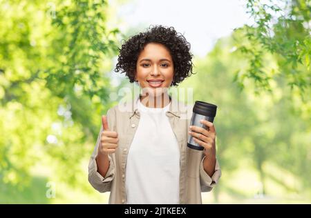 femme avec une tasse thermo ou un gobelet pour les boissons chaudes Banque D'Images