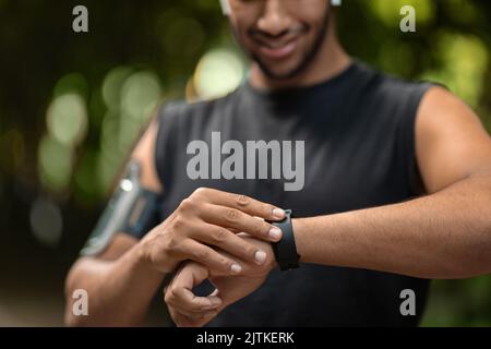 Un sportif noir écourté a mis en place son tracker d'activité Banque D'Images