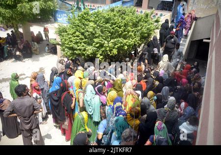 Un grand nombre de femmes pauvres bénéficiaires du Programme de soutien du revenu Benazir Bhutto (BISP) se réunissent à leur tour pour obtenir de l'argent au centre de collecte local à Hyderabad mercredi, 31 août 2022. Banque D'Images