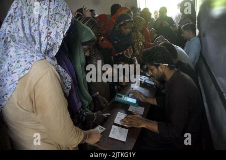 Un grand nombre de femmes pauvres bénéficiaires du Programme de soutien du revenu Benazir Bhutto (BISP) se réunissent à leur tour pour obtenir de l'argent au centre de collecte local à Hyderabad mercredi, 31 août 2022. Banque D'Images