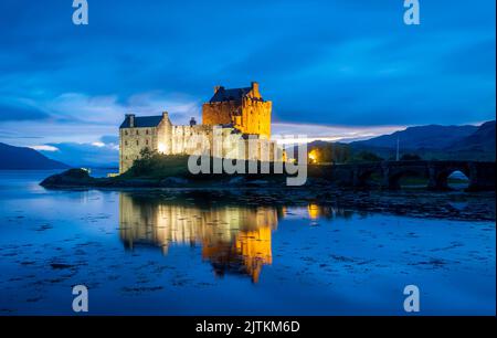 Dornie, Scoltland, Royaume-Uni, 21 juillet. Le célèbre château Eilean Donan illuminé dans la soirée avec de belles lumières et de réflexion dans l'eau. Banque D'Images