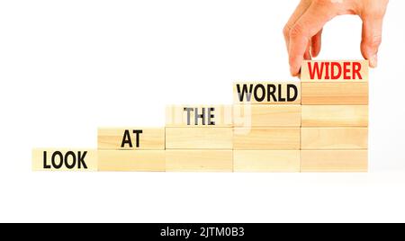 Regardez le symbole du monde entier. Les mots de concept regardent le monde plus large sur des blocs de bois sur un magnifique fond blanc. Main d'homme d'affaires. Entreprise et Banque D'Images