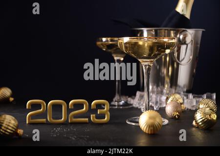 Champagne du nouvel an dans des verres à vin et bouteille dans un seau décoré de boules dorées de Noël. Banque D'Images