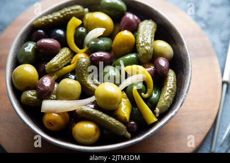 Cornichons marinés, oignons, Chili et divers types d'olives dans un bol Banque D'Images