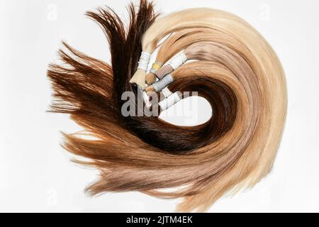 Échantillons de cheveux incurvés pour extension enroulée, différentes couleurs.fond blanc. Banque D'Images