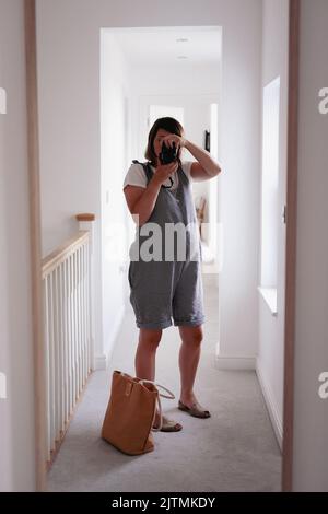 Femme enceinte prenant photo de selfie dans le miroir Banque D'Images