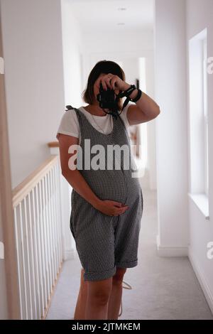 Femme enceinte prenant photo de selfie dans le miroir Banque D'Images