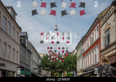 H C Andersen haut de chapeaux accroché sur une rue commerçante dans le centre d'Odense, Danemark, 28 août 2022 Banque D'Images