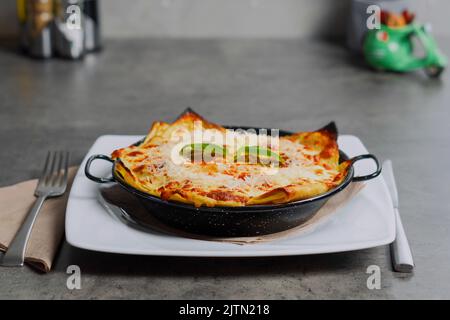 Lasagnes traditionnelles à base de bolognaise de bœuf haché surmontée de feuilles de basilic Banque D'Images