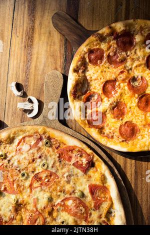 Trois pizzas aux saveurs différentes. Pepperoni, fromage, pomme de terre, oignon, tomate. Pizza italienne de qualité. Banque D'Images