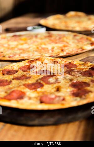 Trois pizzas aux saveurs différentes. Pepperoni, fromage, pomme de terre, oignon, tomate. Pizza italienne de qualité. Banque D'Images