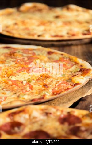 Trois pizzas aux saveurs différentes. Pepperoni, fromage, pomme de terre, oignon, tomate. Pizza italienne de qualité. Banque D'Images