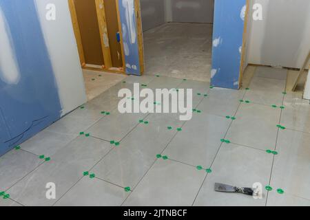 Dans le processus de construction d'une nouvelle maison, la salle de bains est en train d'être carrelée avec des carreaux de céramique installés Banque D'Images