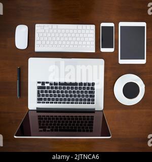 L'espace de travail sans fil. Prise de vue en grand angle de divers appareils numériques sur une table. Banque D'Images