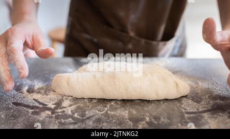 Le processus de fabrication de baguettes traditionnelles françaises. Former un blanc à partir de la pâte. Vue avant. Banque D'Images