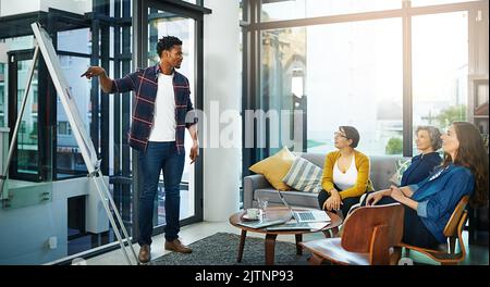 Heres mon plan directeur. Un homme d'affaires créatif qui donne une présentation à ses collègues dans le bureau. Banque D'Images