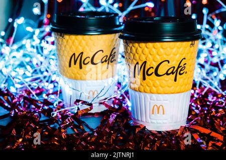 Deux coupes de Noël de McDonald's sur fond d'une guirlande de guirlande de guirlandes rouges. Kiev, Ukraine, 31 mars 2021 Banque D'Images