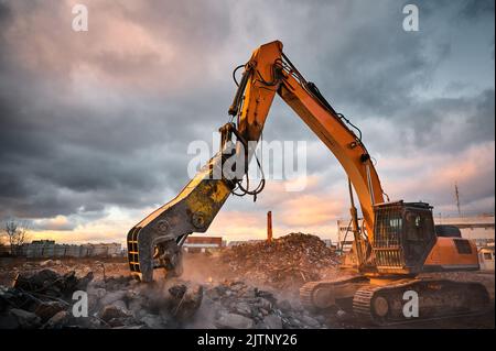 Pelle hydraulique avec presses à concasseur pile de ciment renforcé Banque D'Images