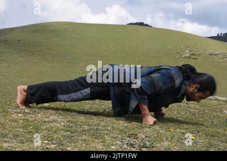 Vue latérale d'un jeune Indien qui fait des poups de poing dans la montagne Banque D'Images