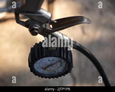 Pistolet de gonflage à main avec manomètre sur fond flou Banque D'Images