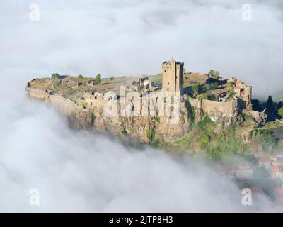 VUE AÉRIENNE. Forteresse de Polignac, sur une mesa basaltique avec le brouillard du matin. Polignac, haute-Loire, Auvergne-Rhône-Alpes, France. Banque D'Images