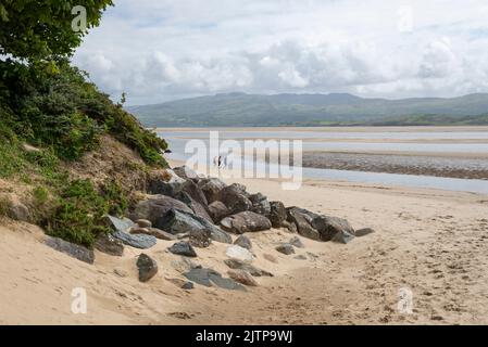 Marcheurs sur la plage de Borth-y-Gest surplombant l'estuaire de Glaslyn dans le nord du pays de Galles. Banque D'Images