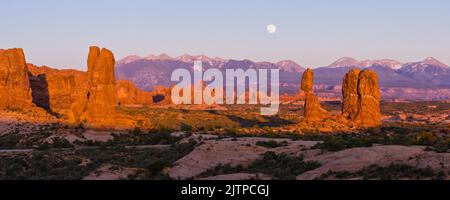 Lever de lune sur les montagnes de la Sal et Balanced Rock dans le parc national d'Arches, Moab, Utah. L'arche de la tourelle est au centre. Banque D'Images