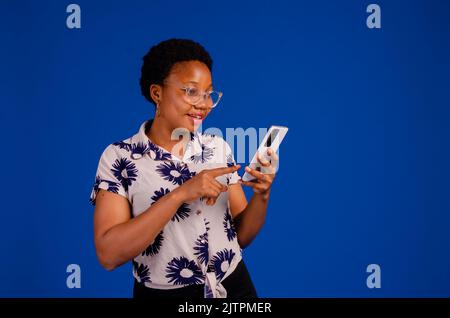 Portrait d'une femme blonde heureuse souriant et utilisant un téléphone portable Banque D'Images